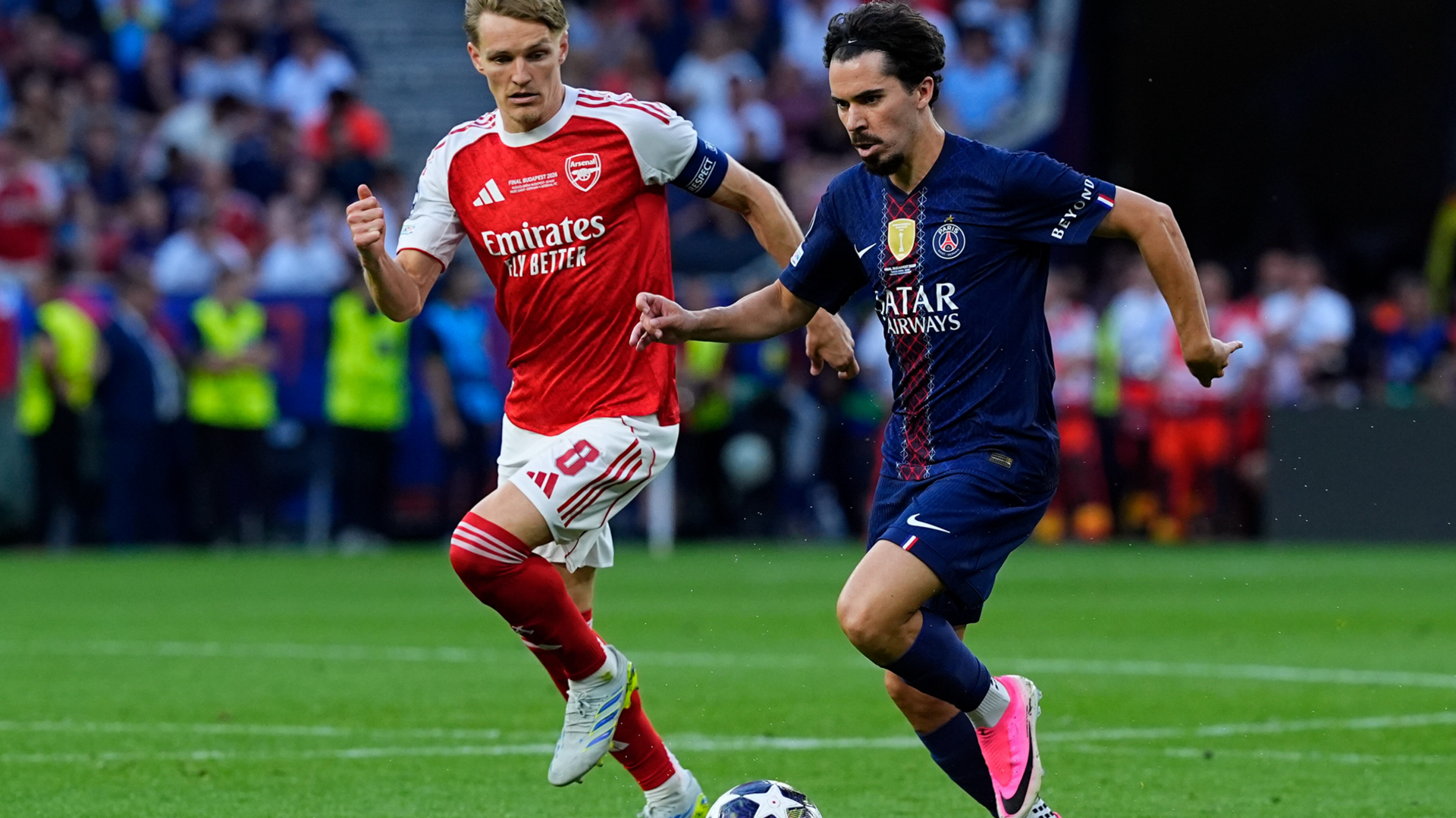 Arsenal captain Martin Odegaard and PSG winger Vitinha run withe the ball during the 2026 Champions League Final