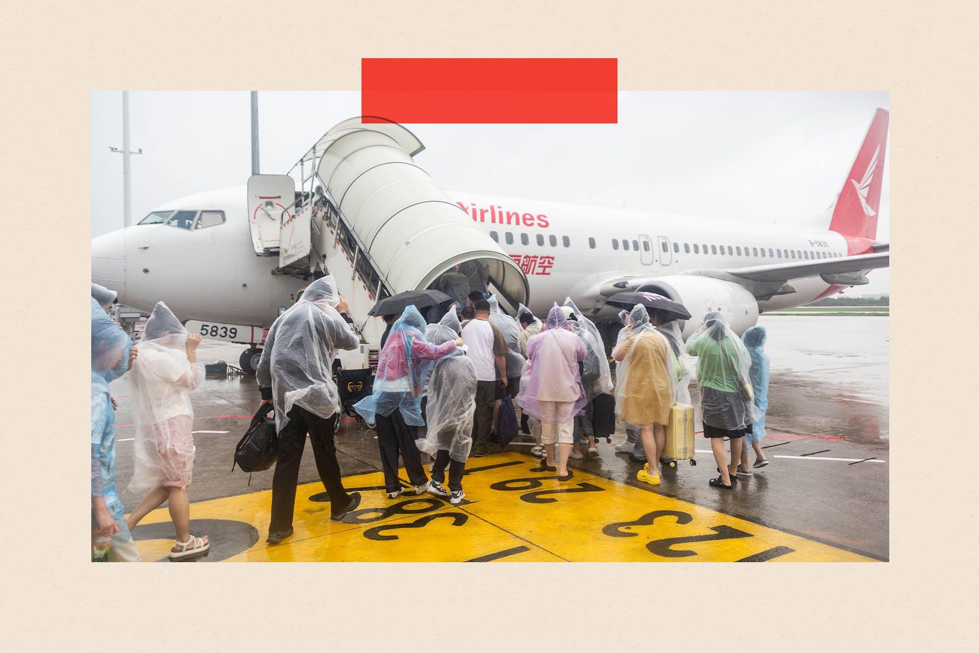 A group of people in clear waterproof ponchos boarding a plane