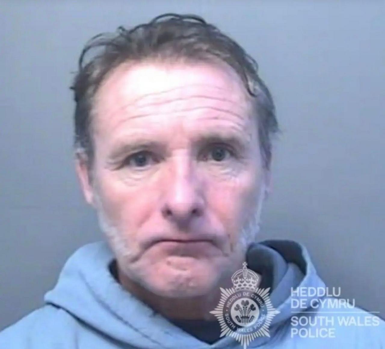 Police mugshot of Christopher Haynes, who is middle-aged with greying hair. He is wearing a grey hoodie.