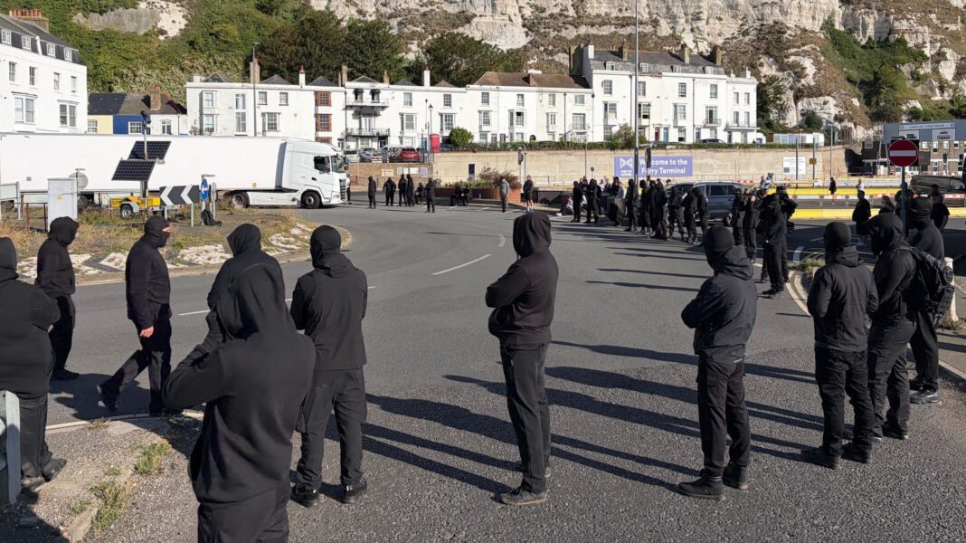 Use all powers necessary on anti-migrant protests, home secretary tells police People in black tracksuits and with face coverings on block access to the Port of Dover.