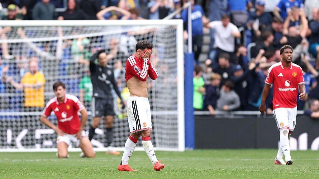Manchester United players react after conceding a goal