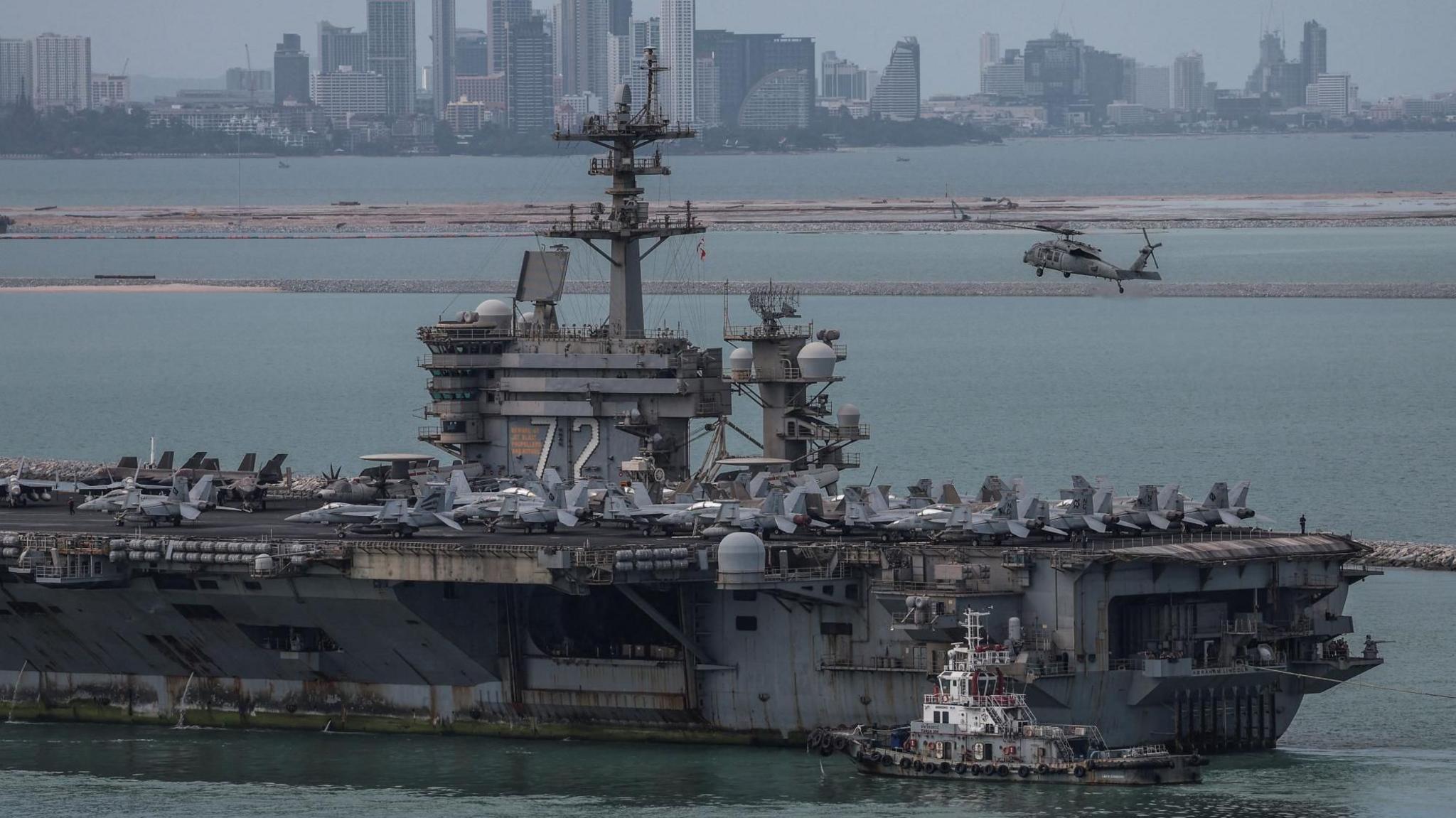 The U.S. Navy Nimitz-class aircraft carrier USS Abraham Lincoln sails toward Laem Chabang Port before docking for a rest stop following a long deployment in the Middle East.