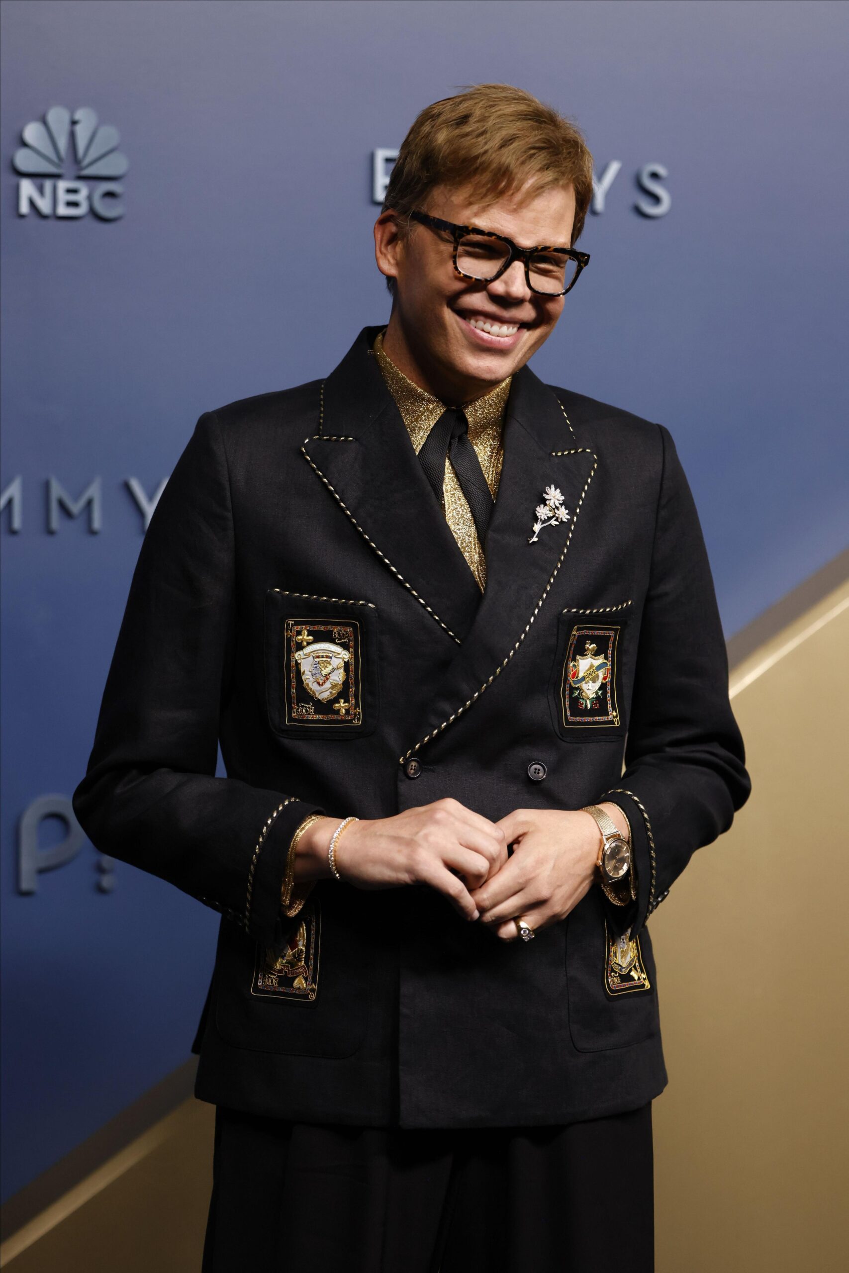 Jeff Hiller smiling in a black embellished suit