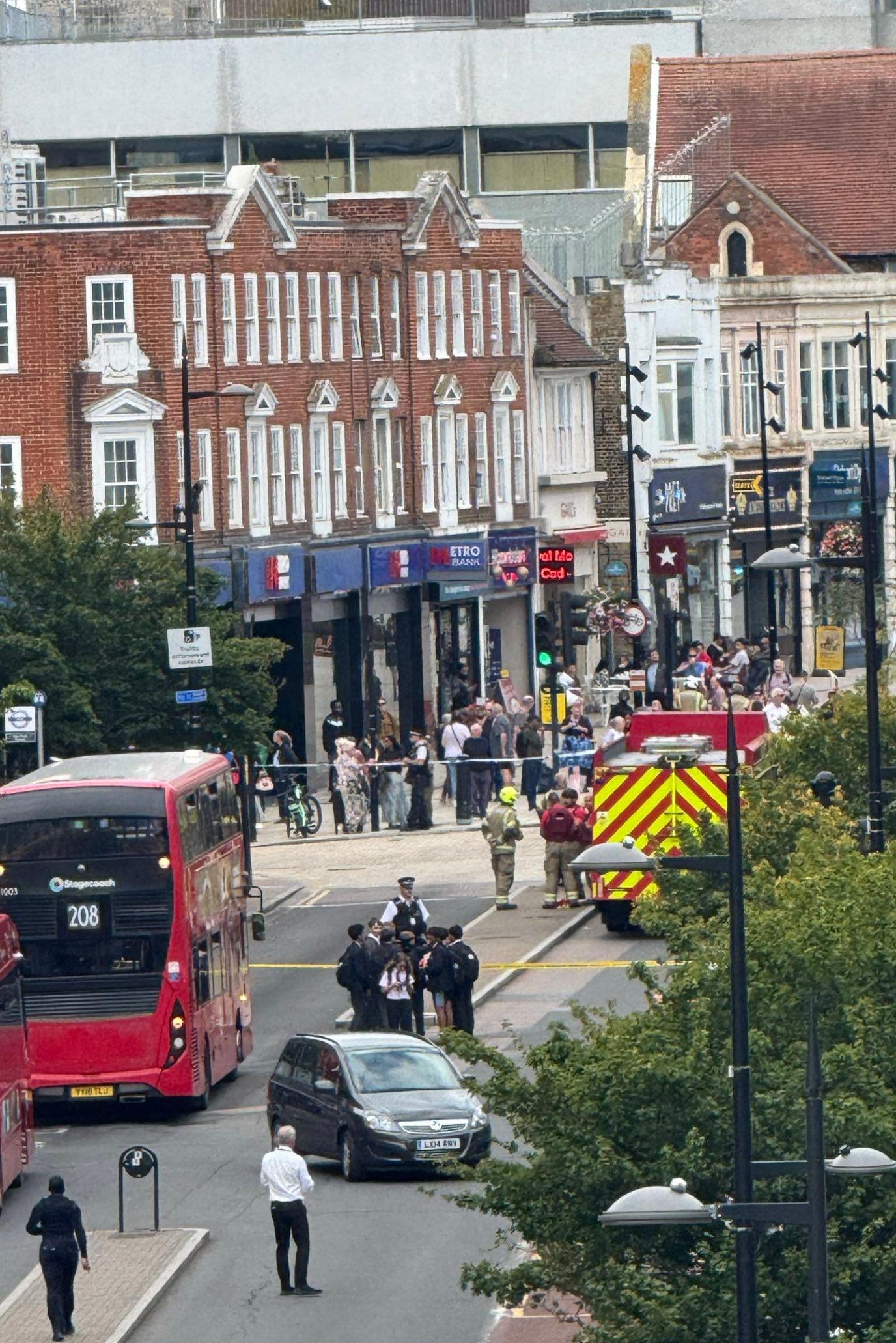 Shot of the high street through a window with London Fire Brigade in attendance and a police cordon in place.