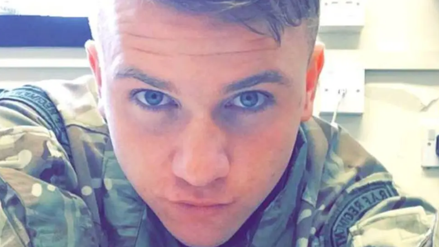 A headshot of a man wearing a military uniform. He is looking into the camera.