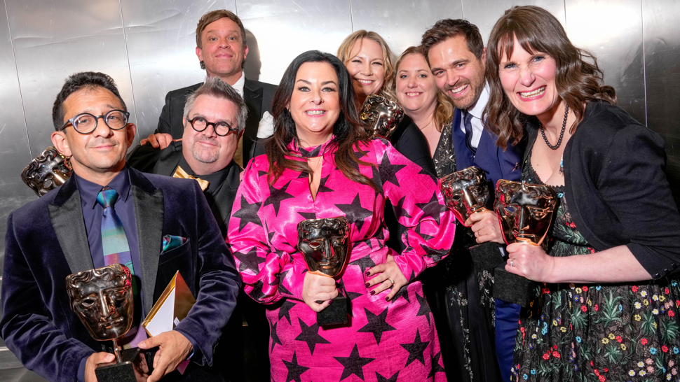 Jon Sen, William Beck, Liza Mellody, Michael Stevenson and Loretta Preece are photographed backstage at the BAFTA Television Awards. They are each holding an award, smiling and looking at the camera.