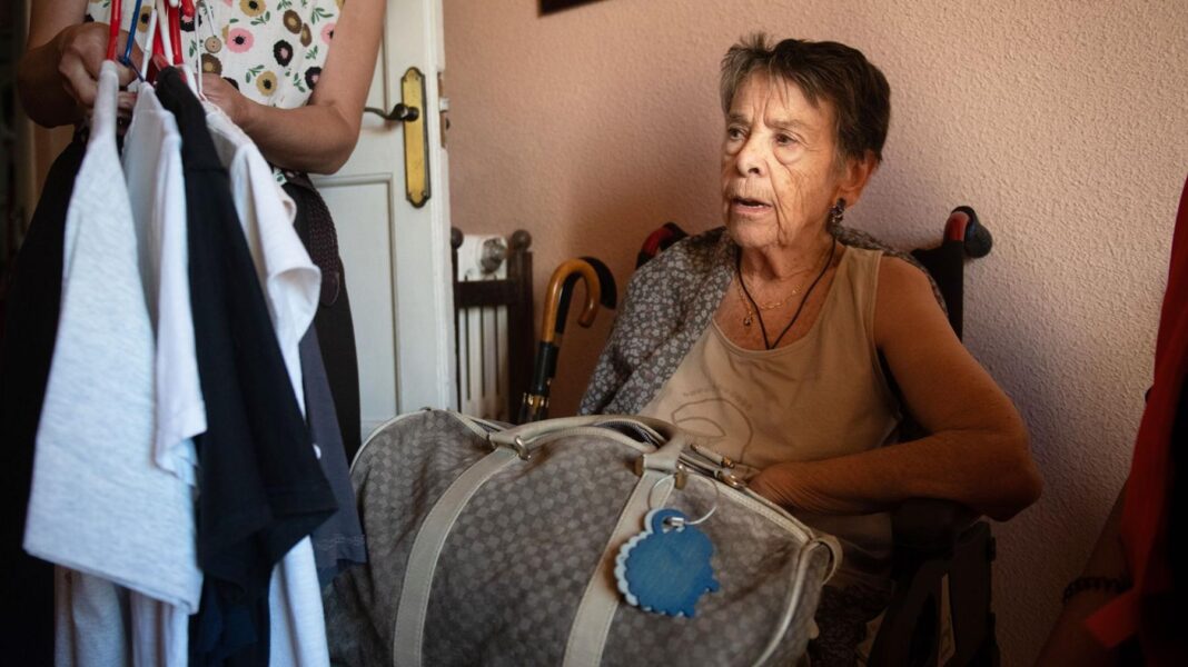 Dramatic eviction of woman aged 87 highlights Spain’s housing shortage Maricarmen, a frail elderly woman, packs a bag with her belongings as she sits in a chair by the door of her flat
