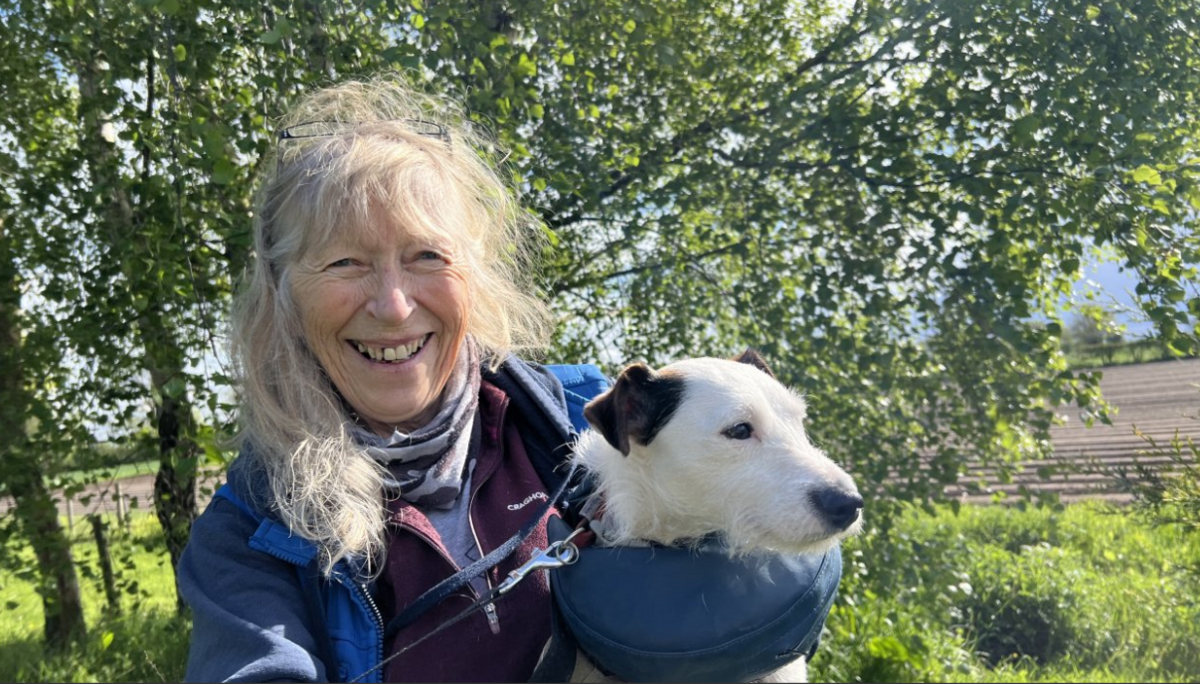 Glynis Elgey pictured with Krakka. She has long fair hair and is wearing a blue jacket. She is holding Krakka in her arms and smiling.