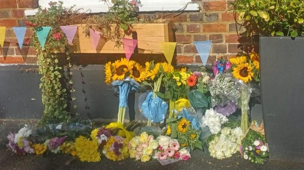 Flowers, such as sunflowers, left in front of a pub