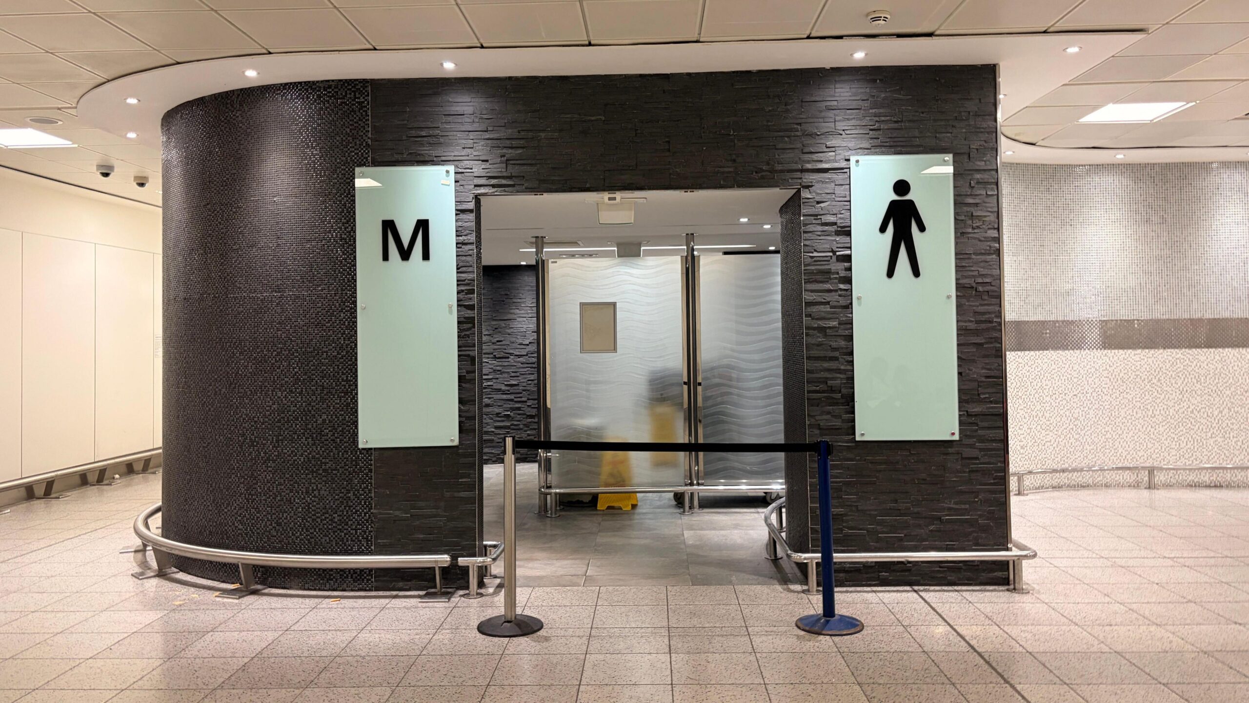 The entrance of a men's toilet which is blocked off.