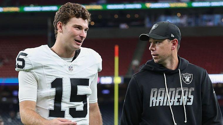 Fernando Mendoza talks with the Las Vegas Raiders head coach Klint Kubiak as they leave the field after an NFL pre-season game in August 2026
