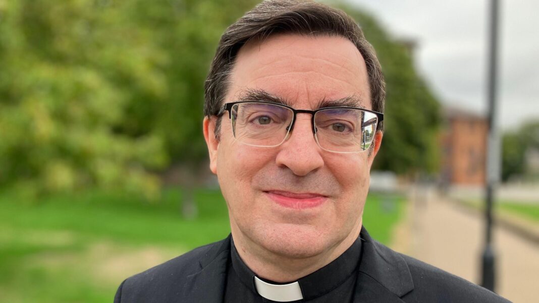 Chaplain settles LGBT sermon unfair dismissal case Rev Bernard Randall, a man with brown hair and glasses, wearing a black jacket and shirt, with a white dog collar.