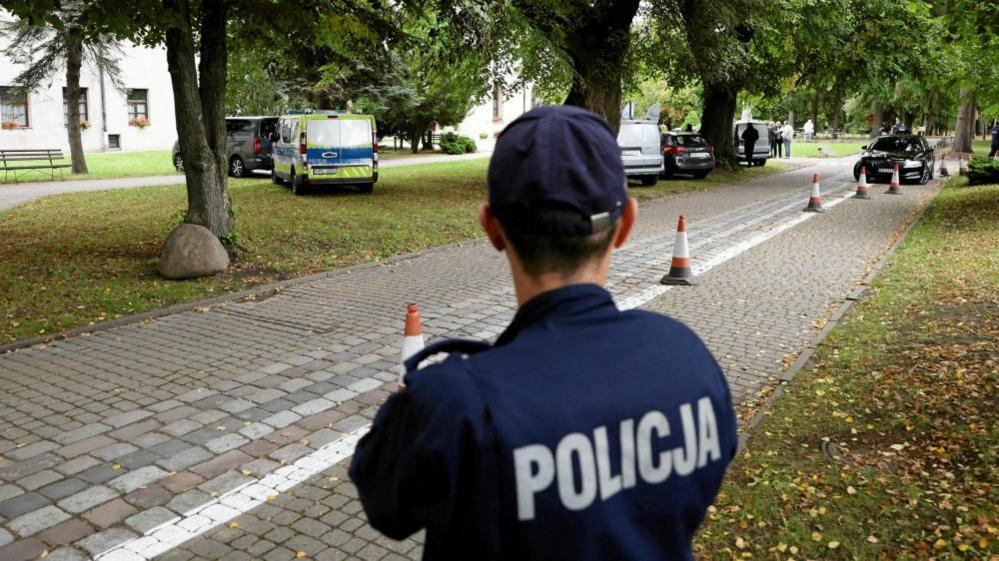 A police officer stands guard near the site of a knife attack on the grounds of a Catholic abbey in Jarosław, south-eastern Poland. Photo: 24 September 2026