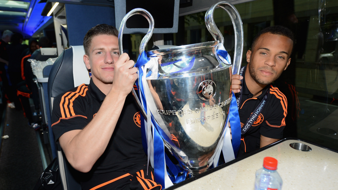 Chelsea players Sam Hutchinson (left) and Ryan Bertrand hold the Champions League trophy on the coach on the way to the victory parade in 2012