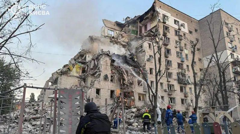 Rescue workers are pictured outside a large building that has been massively damaged by a Russian strike