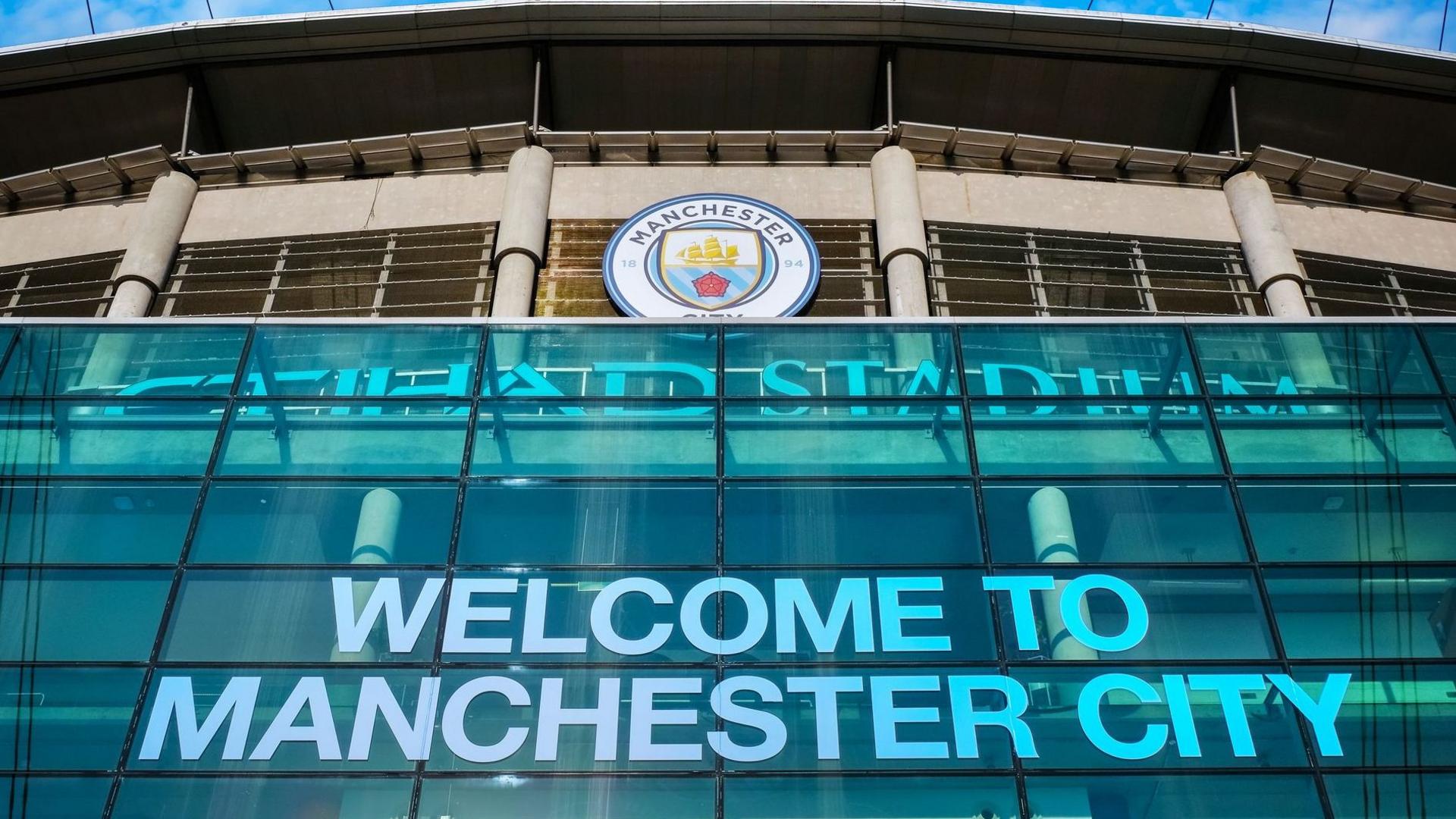 A picture of the outside of the Etihad Stadium and the words "Welcome to Manchester City"