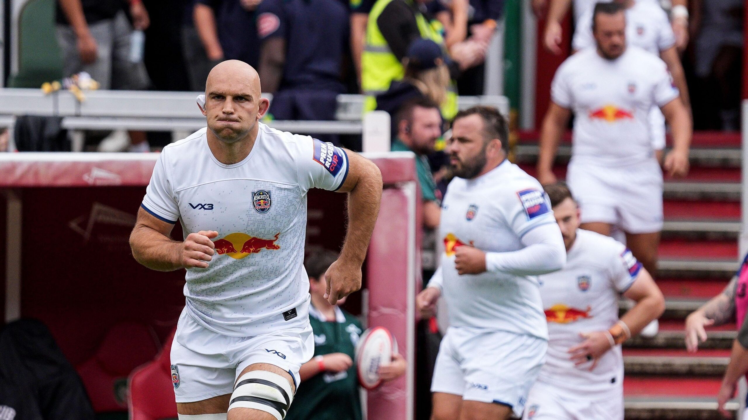 Captain Tom Christie leads out Newcastle Red Bulls in a white kit before their Prem Rugby Cup match at Leicester
