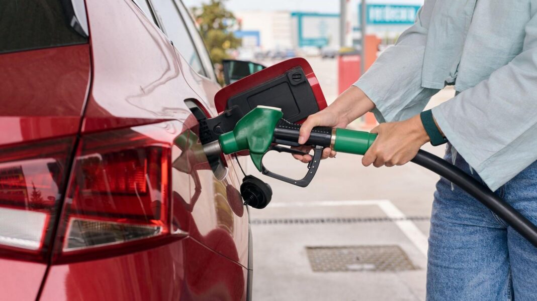 Interest rates held but Bank signals rise if energy prices stay high Woman filling up a red car at a petrol pump