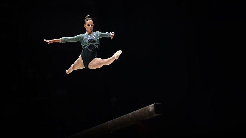 Alice Kinsella leaps high above the balance beam during competition at the British Artistic Gymnastics Championships.