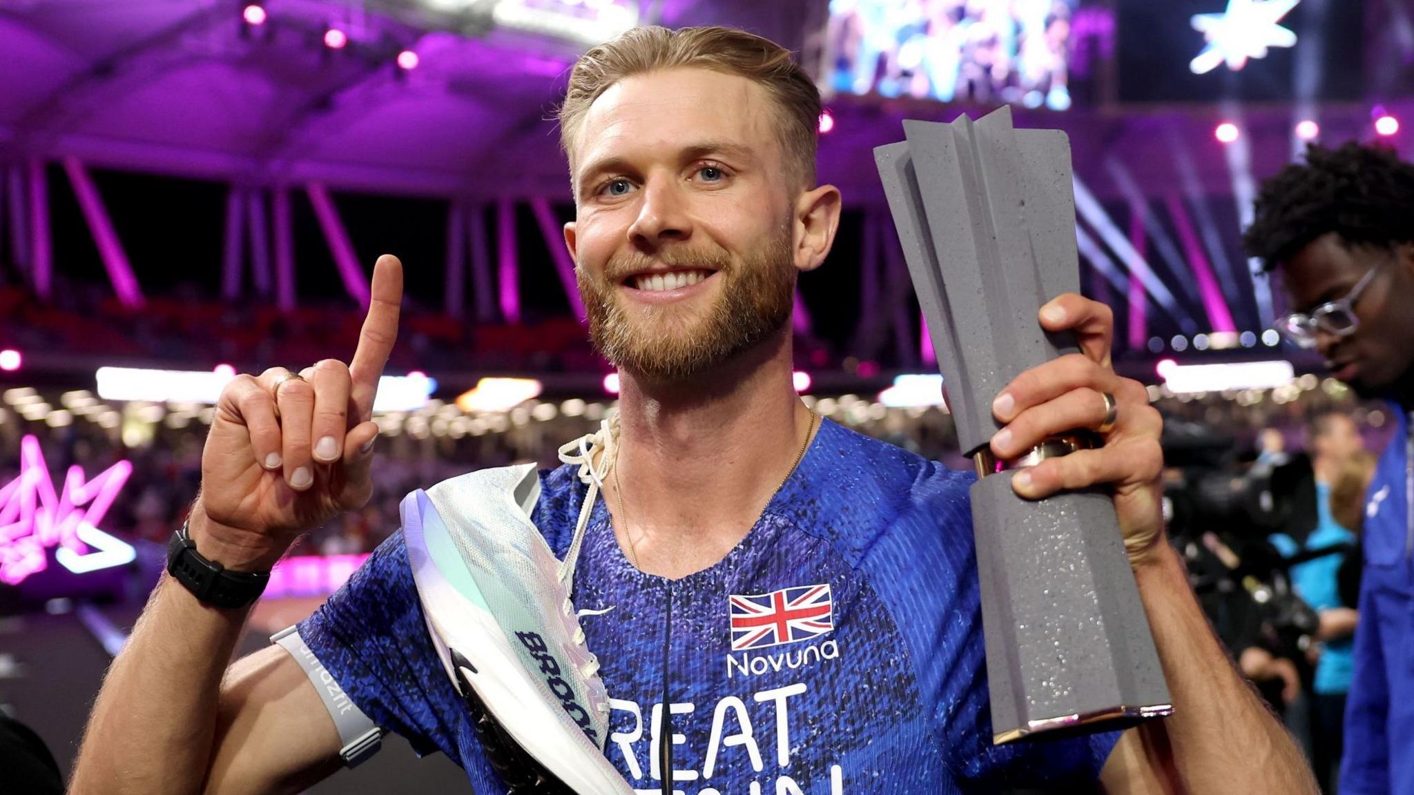 Josh Kerr celebrates with his Ultimate Championship trophy after winning the men's 1500m