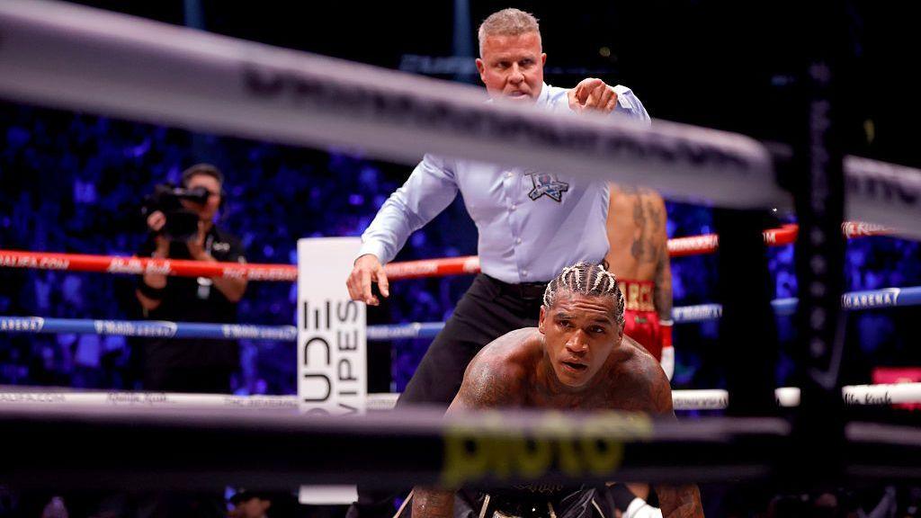 Conor Benn on the canvas with the referee standing over him