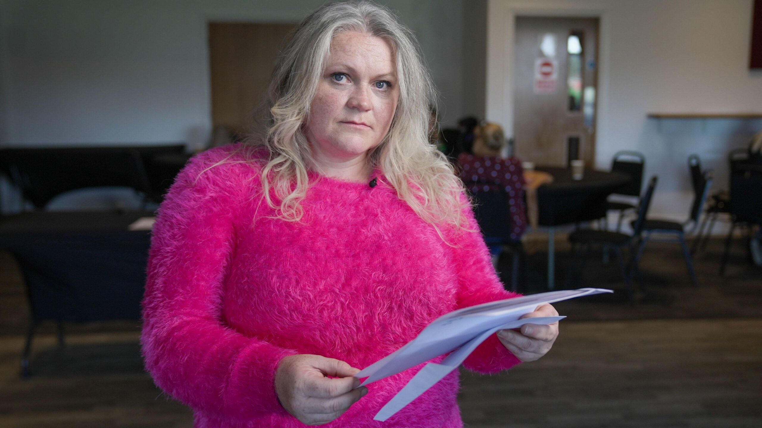 Sam, a resident of Thornton-Cleveleys, holds the blood test results printed on a white piece of paper. She is wearing a bright pink top.