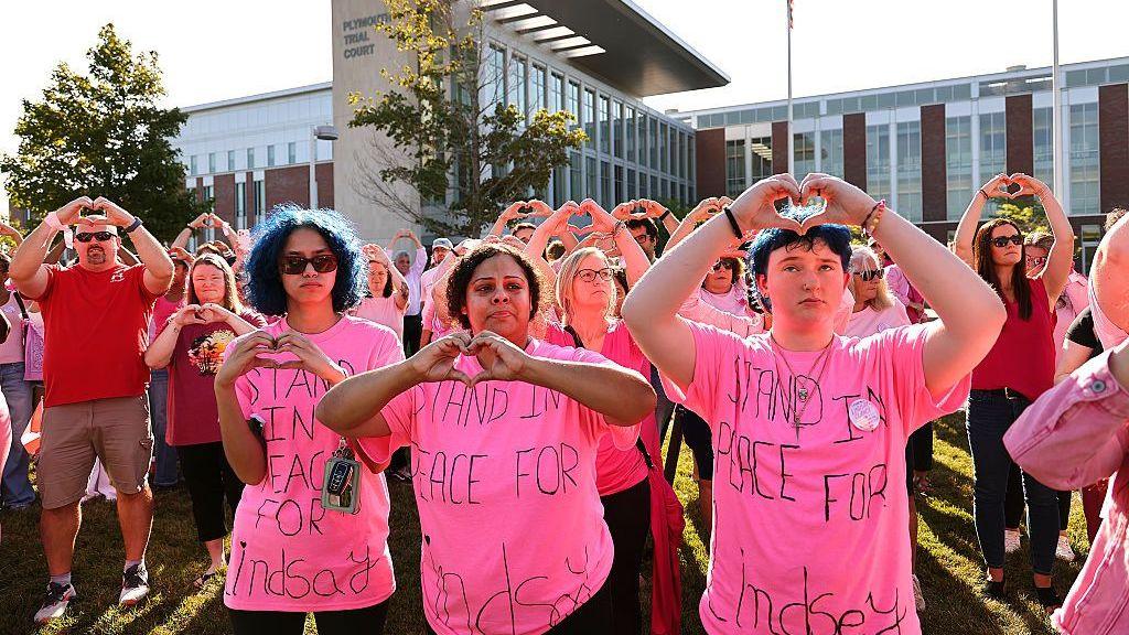 People - many in pink T-shirts with supportive messages for Lindsay Clancy - gathered outside the courthouse. They held up their hands in a heart shape
