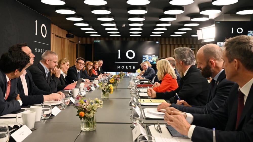 Andy Burnham sits on a long table with the 'No 10 North' logo in the background.