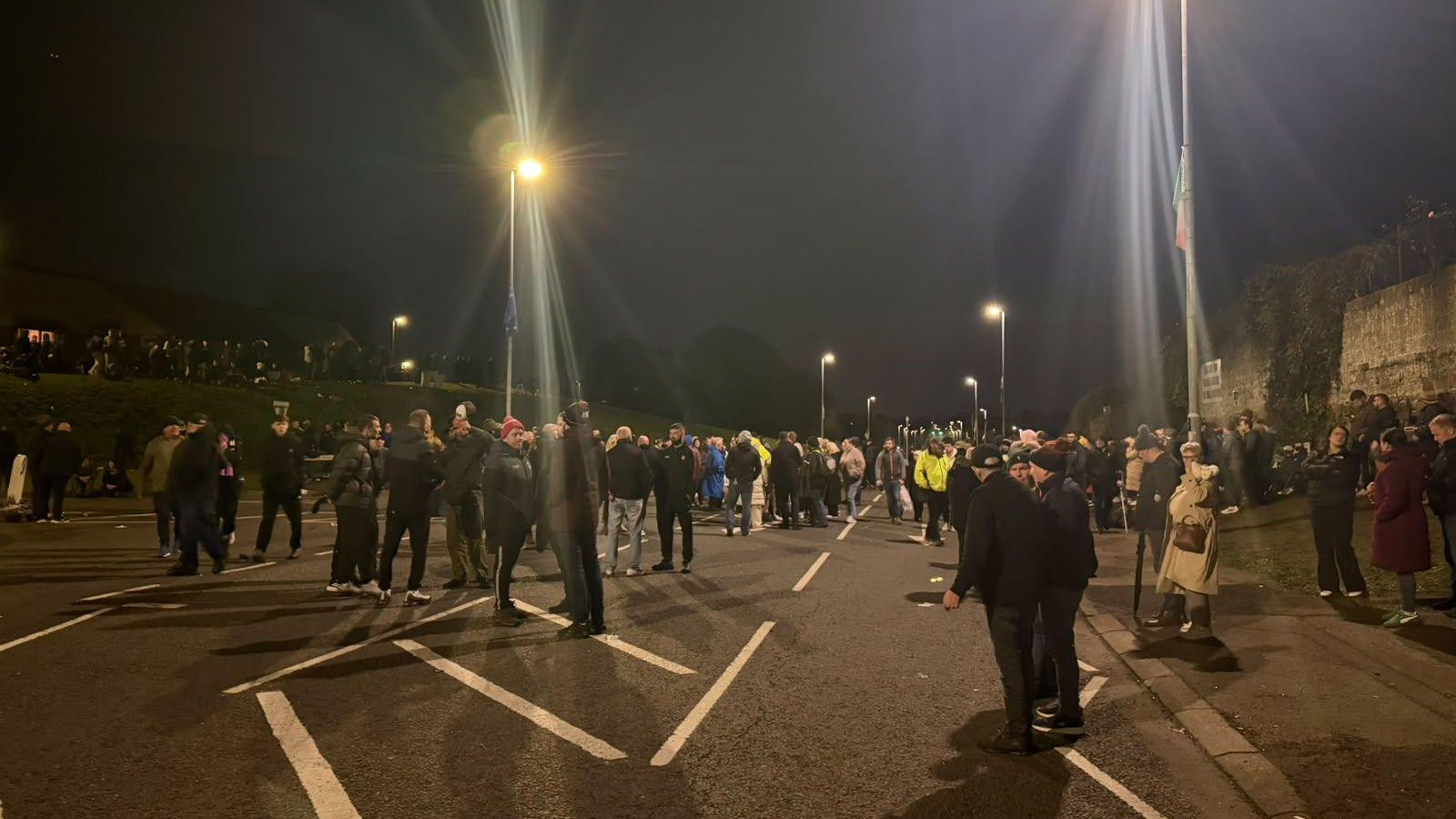 Some protesters, pictured at night, as crowds begin to disperse