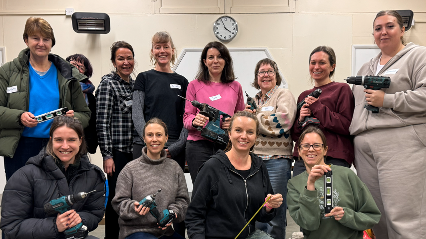 Sarah Bolger and Justine Wortsman taking a group photo with participants on one of their taster sessions. All are smiling. Sarah has three silver necklaces around her neck and is wearing a black shirt. She has long, brown hair.