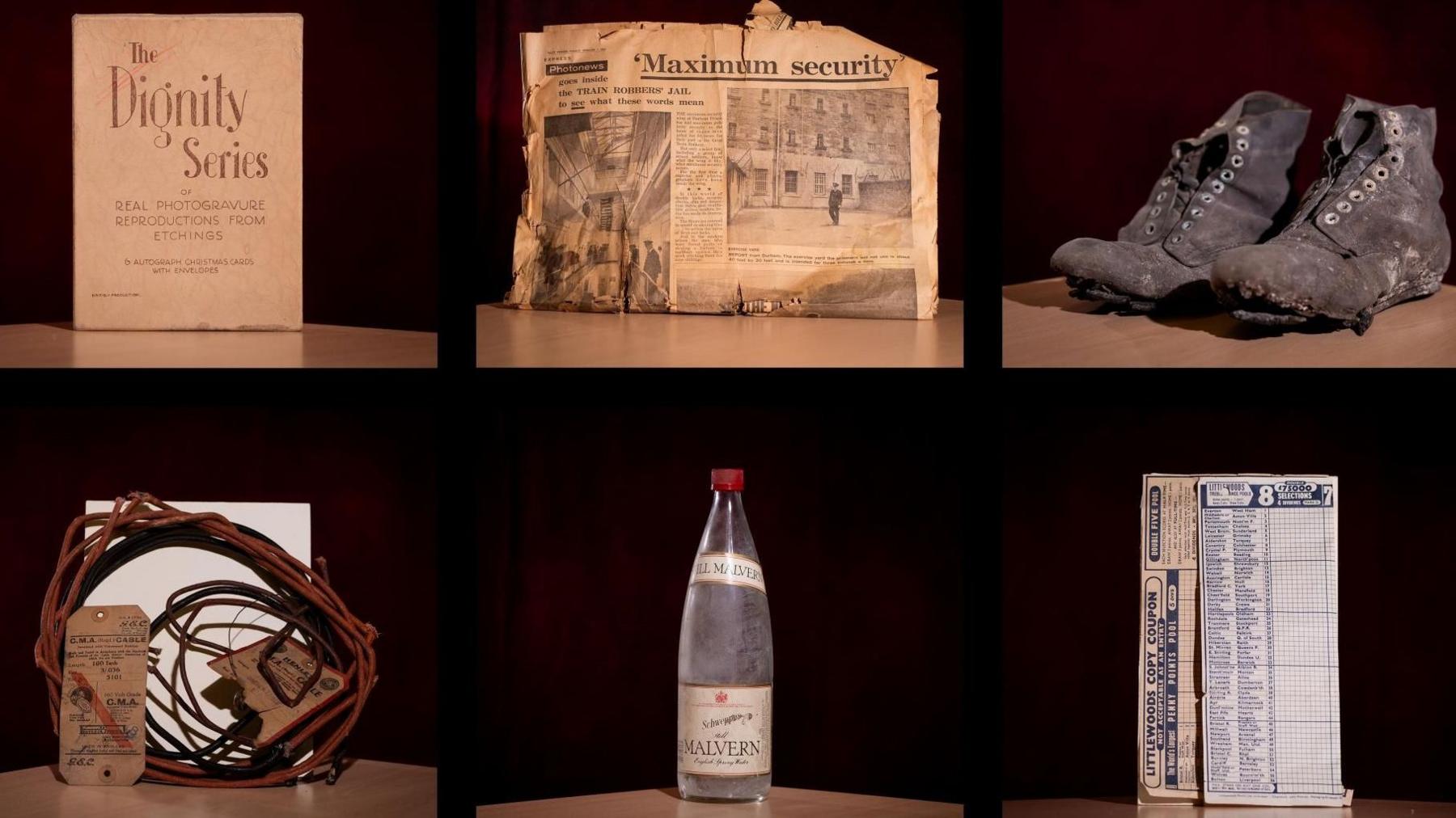 Several items, including an old brown newspaper, battered hobnail boots and a bottle of Schweppes bottled water are displayed side by side.