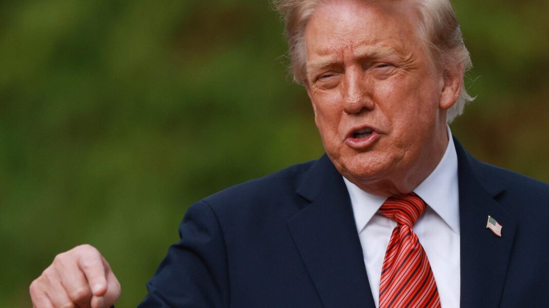 Donald Trump Jr and Bettina Trump say Putin ally paid for some wedding festivities as a ‘gift’ Donald Trump. He has blonde hair, wearing a navy blazer with American pin, white shirt and red tie. He is pointing his finger.
