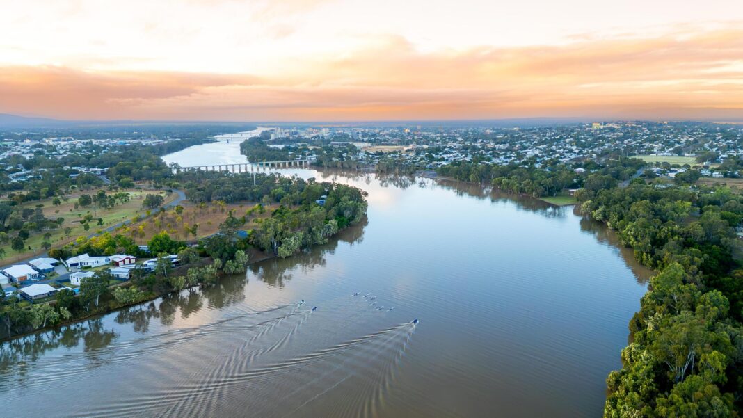 This Olympic river has 500 crocodiles in it – but that’s not the main concern A wide river with trees and homes on either side