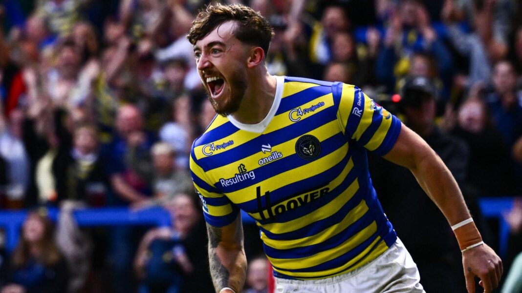 Warrington Wolves winger Matty Ashton, in blue and primrose hoops, shouts in celebration after scoring a try against Hull Kingston Rovers.