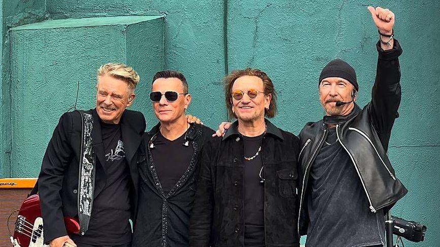 U2 on stage at their former school