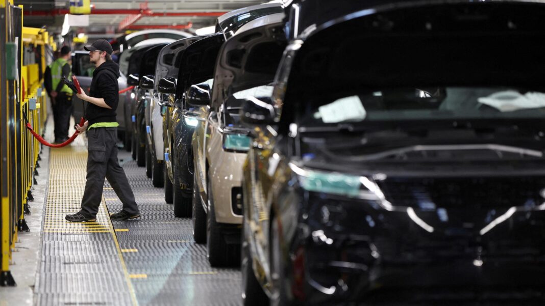 A factory worker assembling vehicles at a Jaguar Land Rover factory site