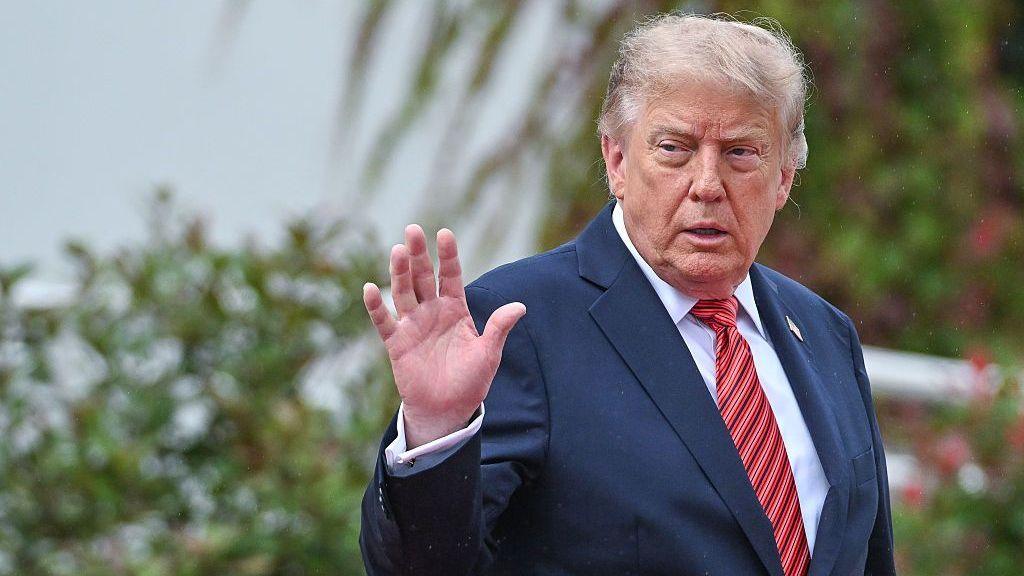 U.S. President Donald Trump turns to wave toward gathered media while walking with Irish President Catherine Connolly during the official farewell as he leaves Aras an Uachtarain on September 12, 2026, in Dublin, Ireland. (
