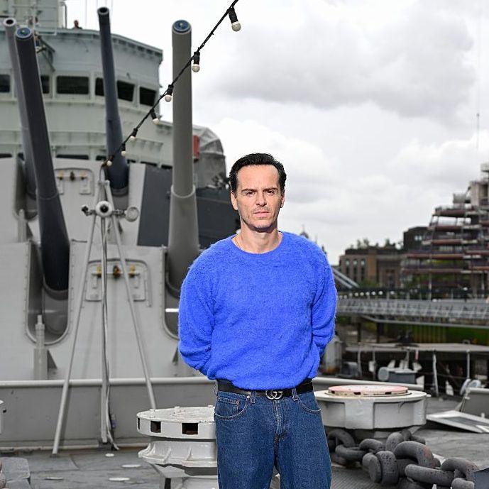 Andrew Scott in a blue jumper and jeans on HMS Belfast