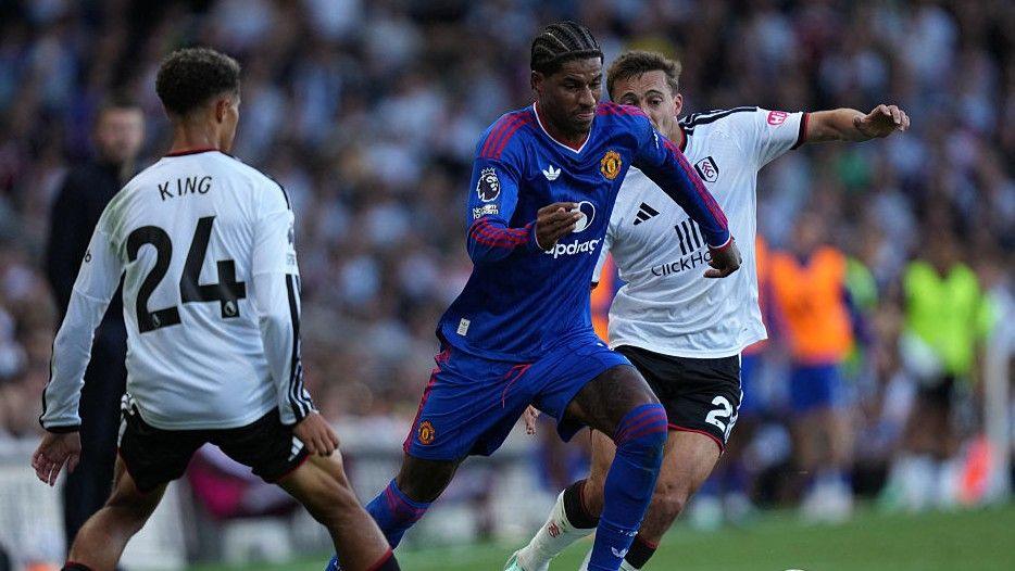 Manchester United's Marcus Rashford tries to beat Fulham pairTimothy Castagne and Josh King