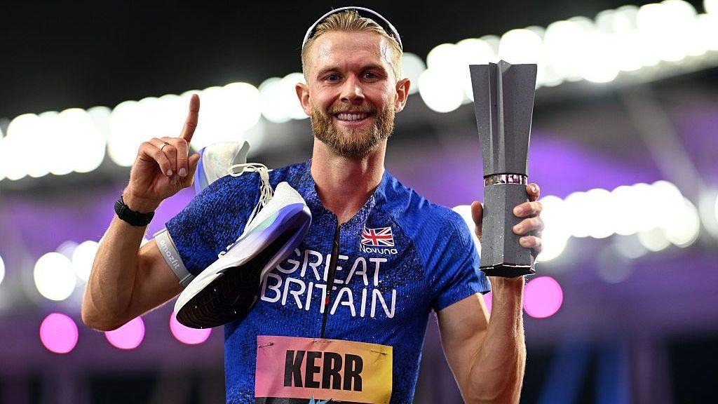 Josh Kerr celebrates while holding the 1500m trophy after winning the inaugural World Athletics Ultimate Champion event in Budapest, Hungary