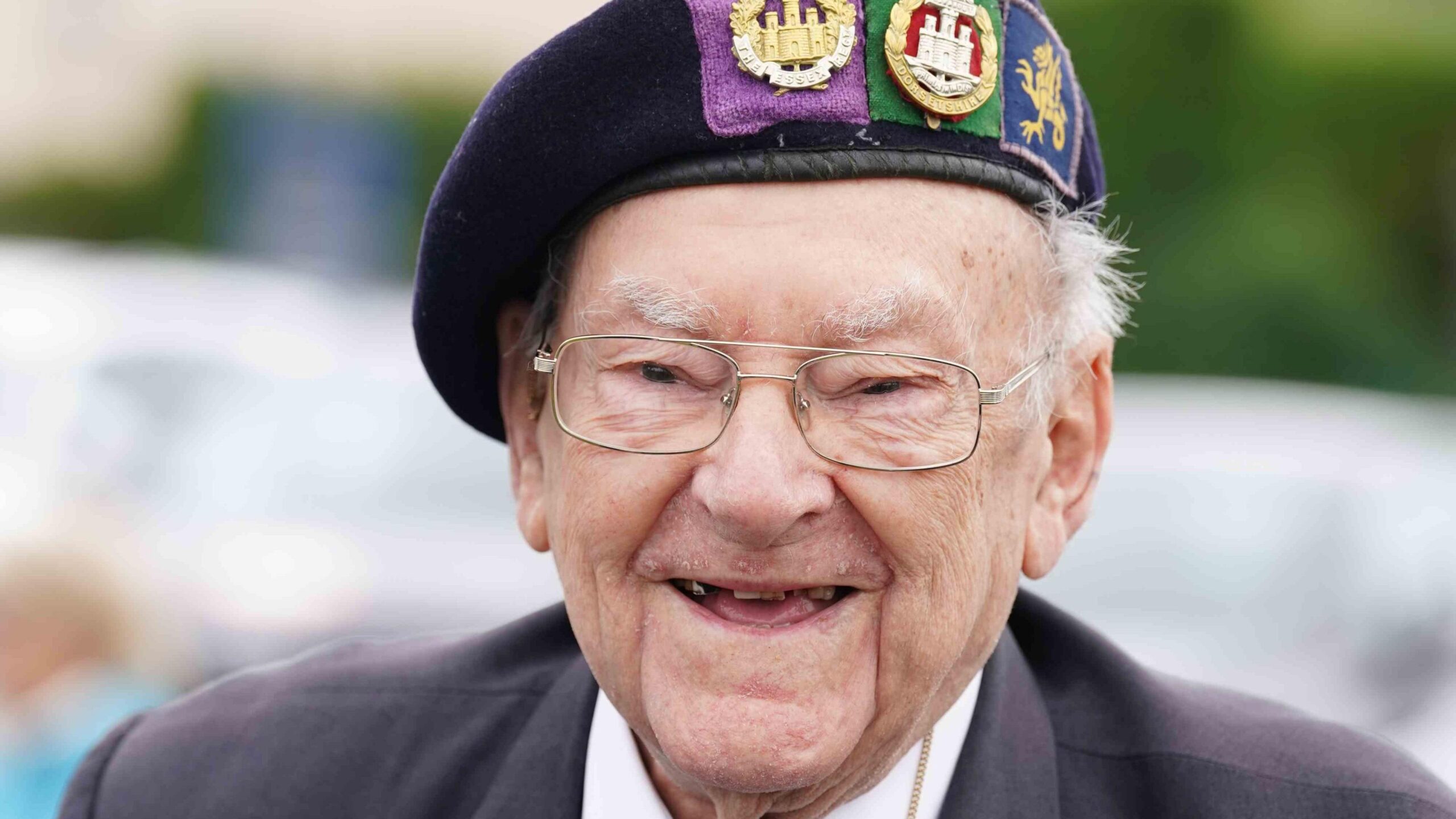 A close-up of Hay, he is smiling and wearing glasses and a uniform