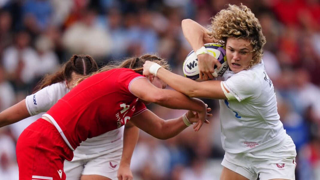 Ellie Kildunne carries the ball and holds off a Canadian opponent