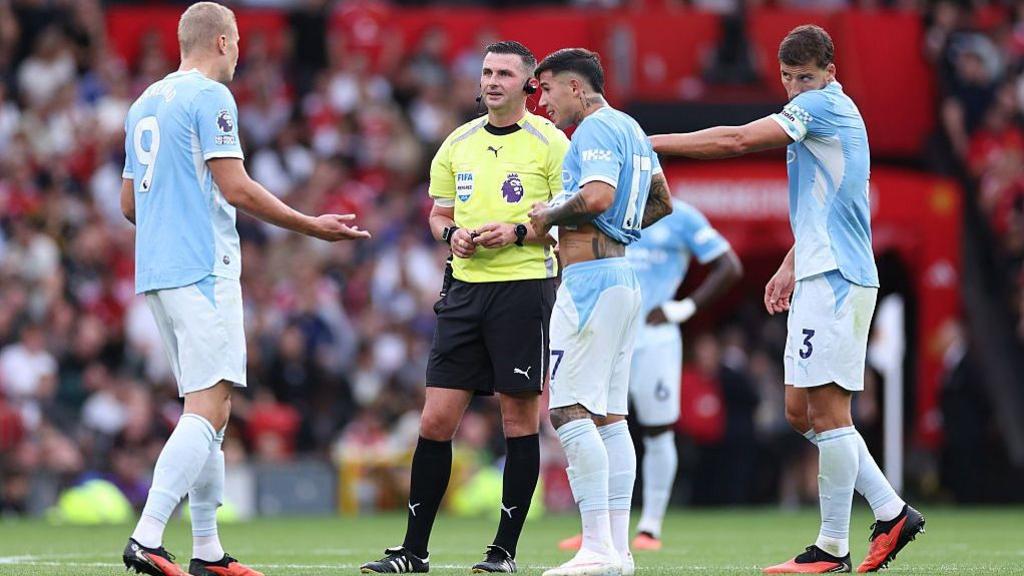 Erling Haaland of Manchester City speaks with referee Michael Oliver as a VAR check is performed after his goal is initially ruled offside