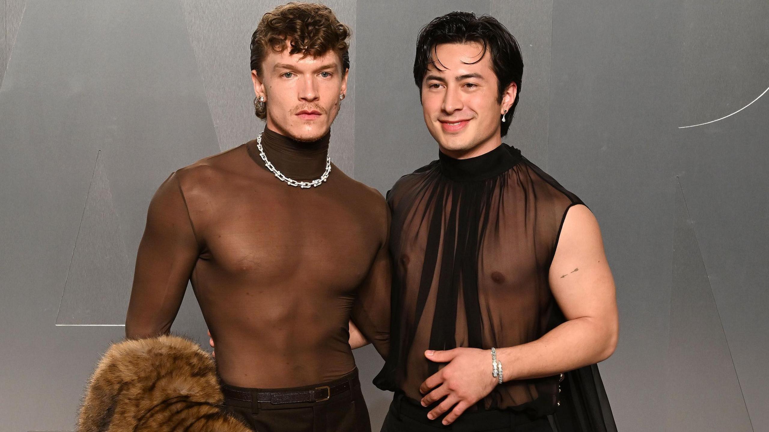 Connor Storrie and Hudson Williams attend the 2026 Vanity Fair Oscar party in LA, they are both wearing sheer chiffon black tops.