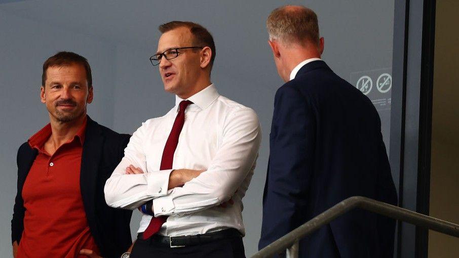 Daniel Kretinsky (centre) with is arms crossed