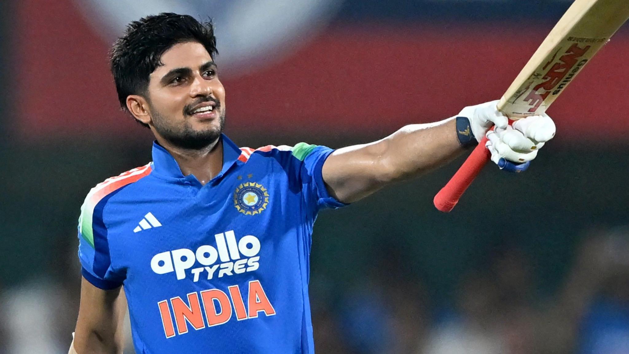 Shubman Gill smiles as he raises his bat