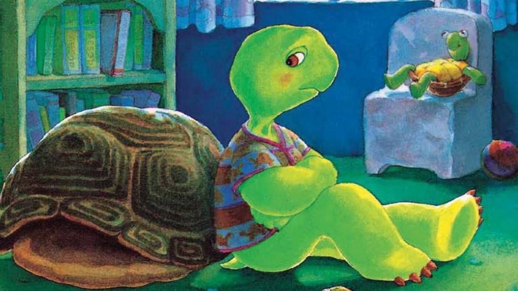 A cartoon image of Franklin the Turtle leaning against his shell, wearing a T-shirt in his bedroom and looking sad.