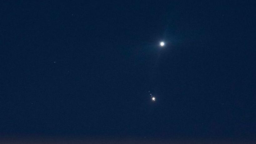 In a dark blue, almost black, sky the two planets of Jupiter and Venus shine brightly in the distance.