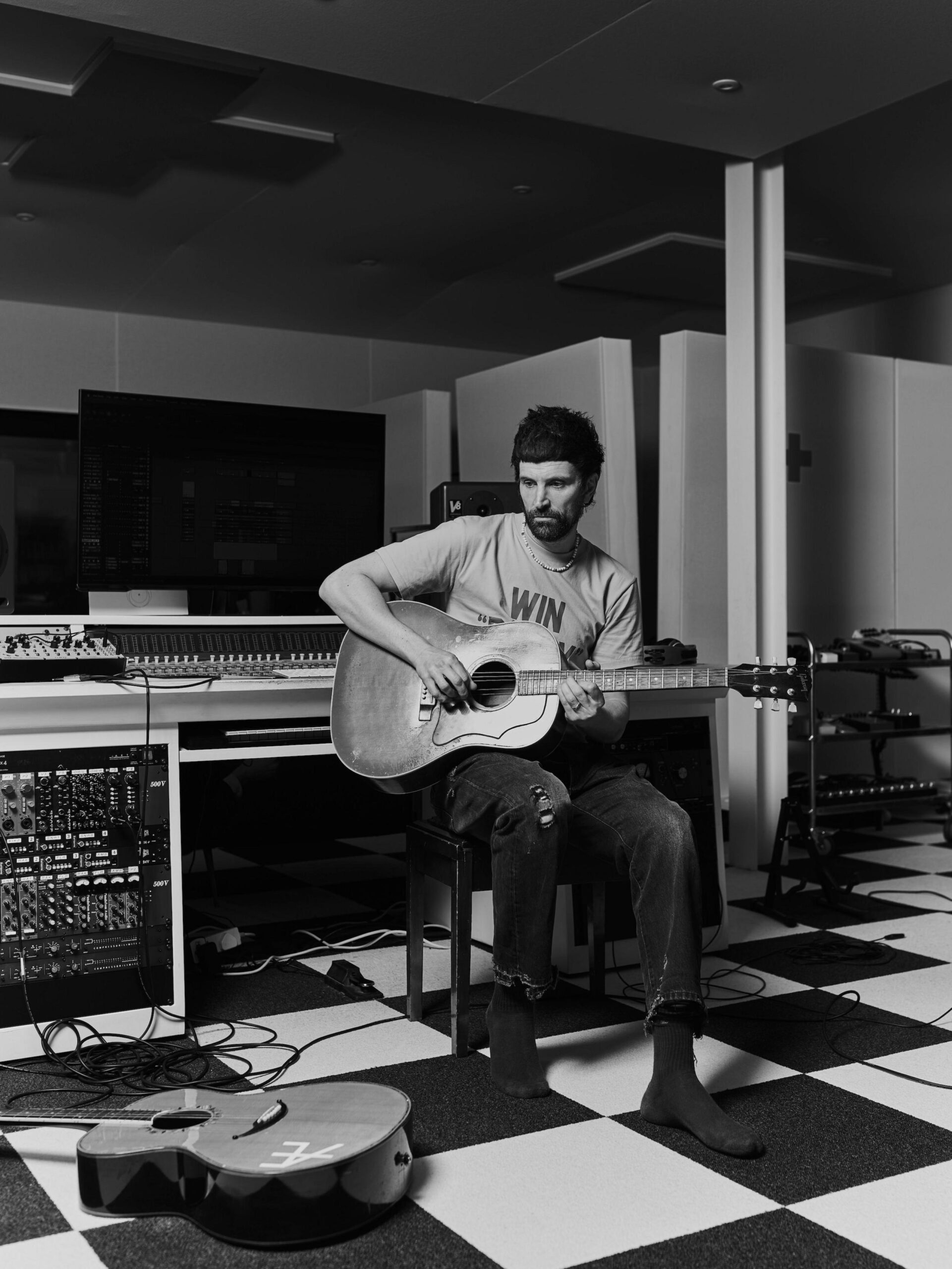 Serge Pizzorno plays guitar in his home studio