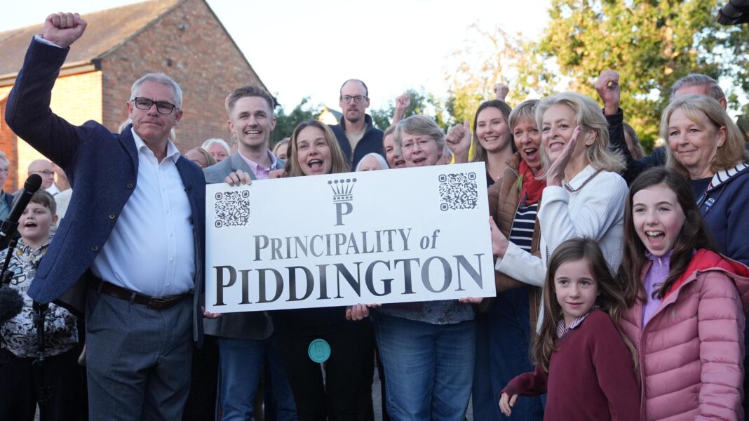 Piddington villagers at sign celebrating after voting overwhelmingly to become an independent state in a symbolic “referendum”.